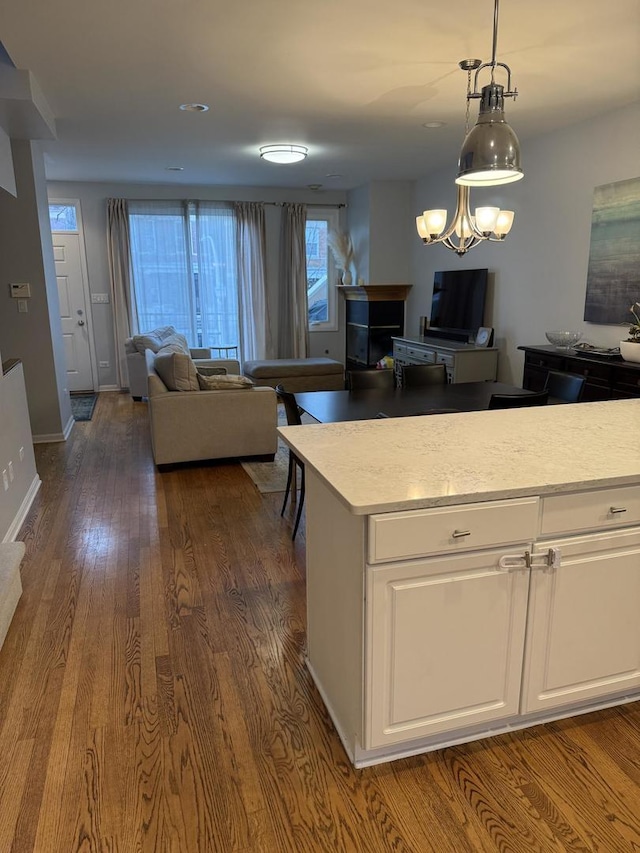 kitchen featuring open floor plan, light countertops, dark wood-style floors, and white cabinets