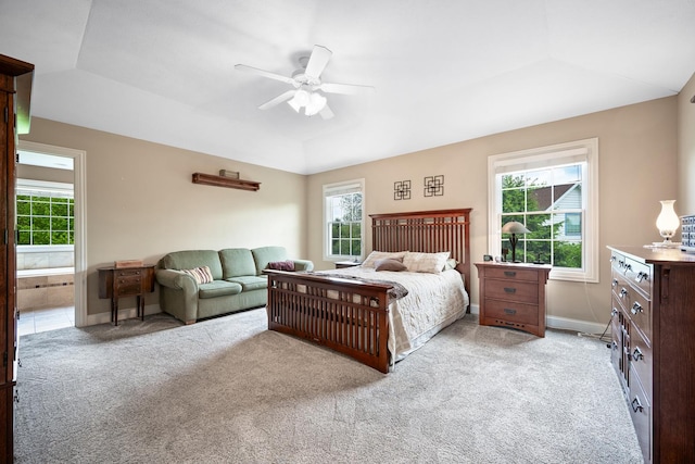 carpeted bedroom with baseboards, multiple windows, connected bathroom, and ceiling fan