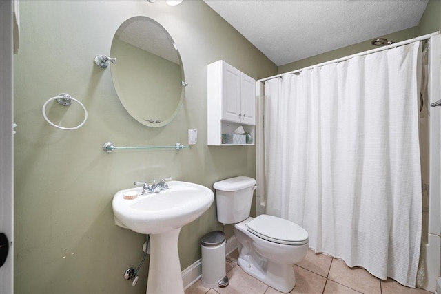 bathroom with toilet, shower / tub combo with curtain, tile patterned flooring, and a textured ceiling