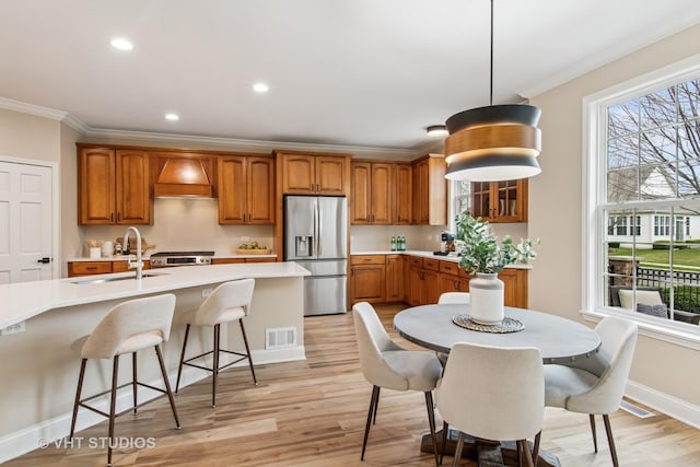 3607 Greystone Ave, Naperville, IL 60564 - kitchen with visible vents, a sink, ornamental molding, brown cabinets, and stainless steel appliances