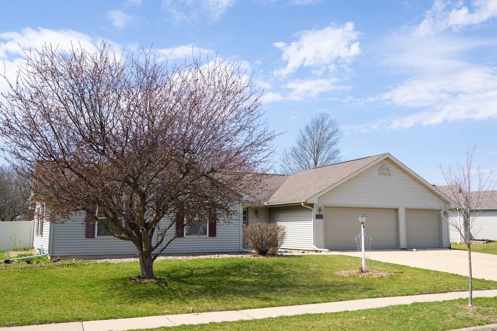 single story home with a front yard, concrete driveway, fence, a shingled roof, and a garage