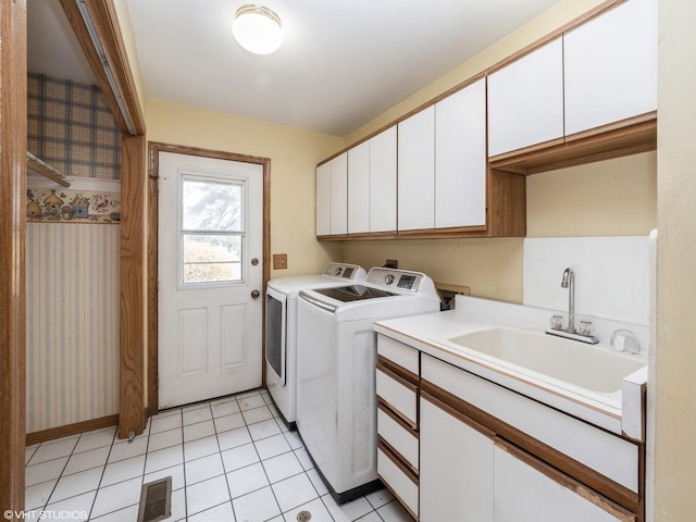 laundry area with visible vents, light tile patterned flooring, a sink, cabinet space, and washer and clothes dryer