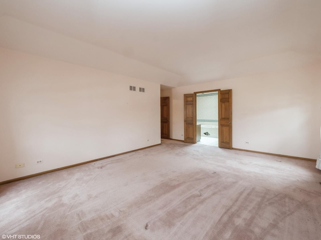empty room featuring light colored carpet and baseboards