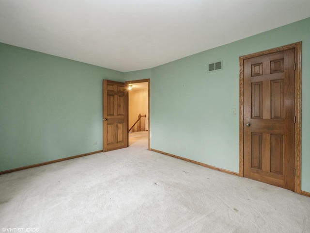 spare room with baseboards, visible vents, and carpet floors