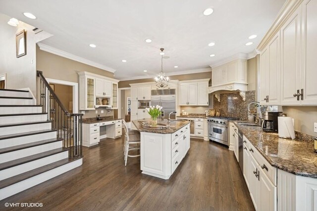 4020 Noble Ct, Northbrook, IL 60062 - kitchen with built in appliances, crown molding, a kitchen island with sink, dark wood-style floors, and a breakfast bar area
