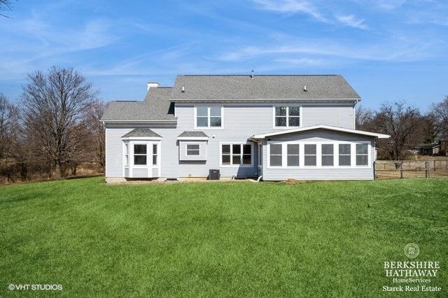 1301 W Clinton Ave, Farmer City, IL 61842 - back of property featuring a lawn and a sunroom