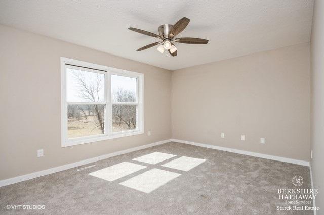 1301 W Clinton Ave, Farmer City, IL 61842 - carpeted spare room with a textured ceiling, baseboards, and ceiling fan