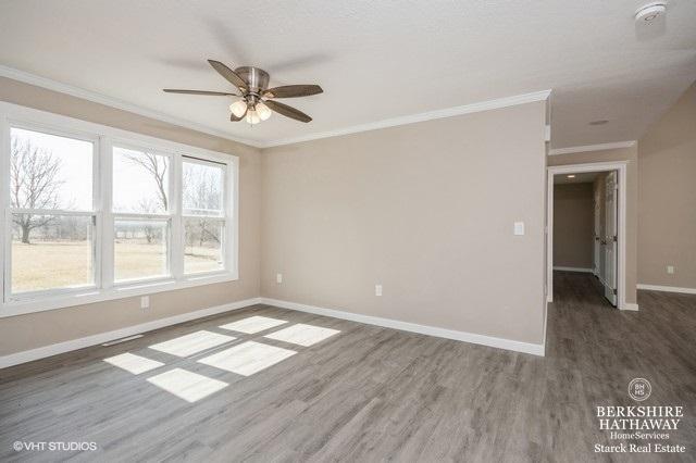 1301 W Clinton Ave, Farmer City, IL 61842 - spare room with wood finished floors, crown molding, baseboards, and ceiling fan