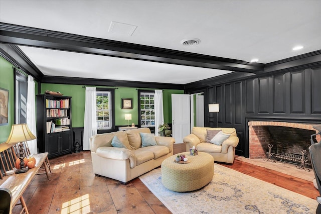 2066 County Road 125 E, Mahomet, IL 61853 - living area featuring beamed ceiling, a fireplace, ornamental molding, visible vents, and hardwood / wood-style flooring
