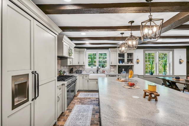 2066 County Road 125 E, Mahomet, IL 61853 - kitchen with a chandelier, a sink, decorative light fixtures, decorative backsplash, and range with two ovens
