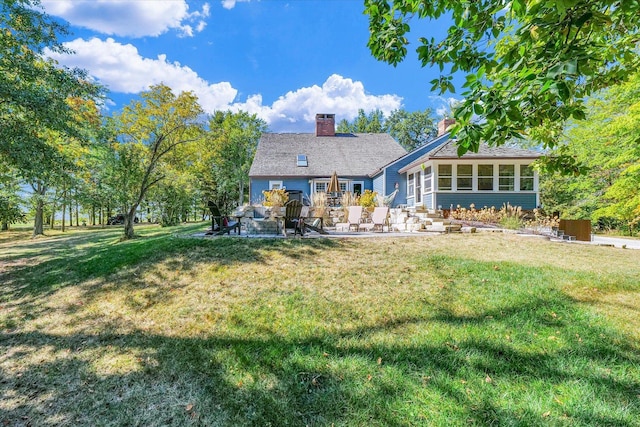 2066 County Road 125 E, Mahomet, IL 61853 - back of property with a sunroom, a yard, a patio area, and a chimney