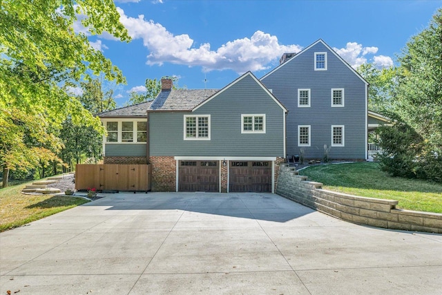 2066 County Road 125 E, Mahomet, IL 61853 - view of front of house featuring a front lawn, brick siding, a chimney, a garage, and concrete driveway