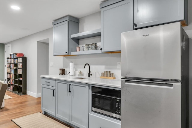 2066 County Road 125 E, Mahomet, IL 61853 - kitchen featuring freestanding refrigerator, open shelves, a sink, light wood finished floors, and gray cabinetry