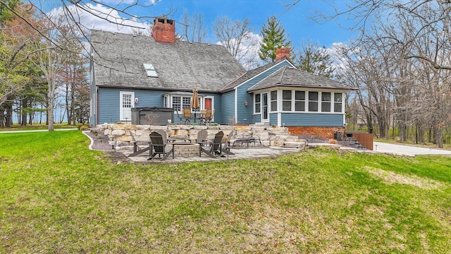 2066 County Road 125 E, Mahomet, IL 61853 - back of property with a patio, a sunroom, a chimney, and a lawn