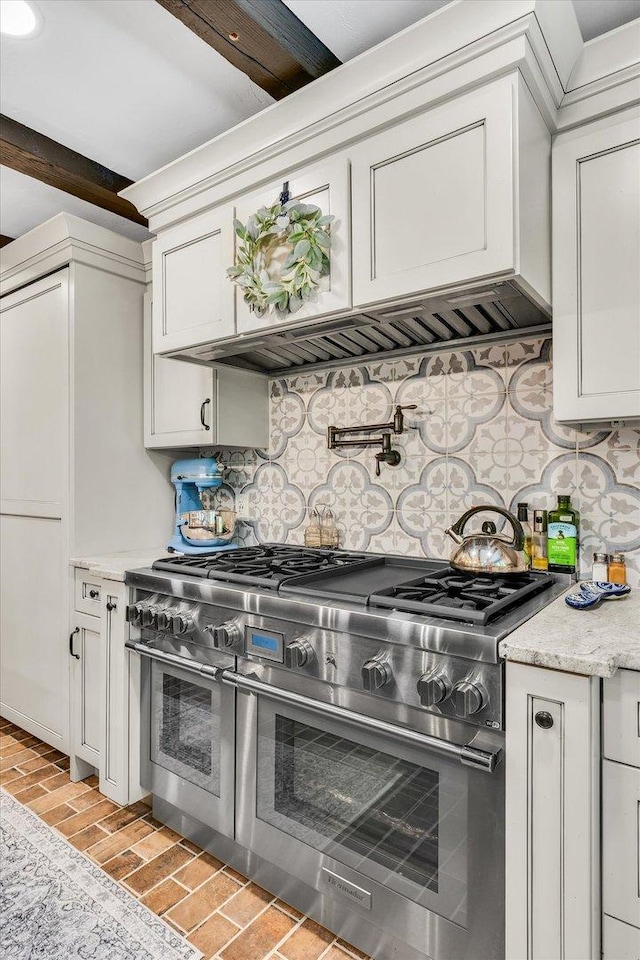 2066 County Road 125 E, Mahomet, IL 61853 - kitchen featuring white cabinets, ventilation hood, decorative backsplash, range with two ovens, and light stone counters
