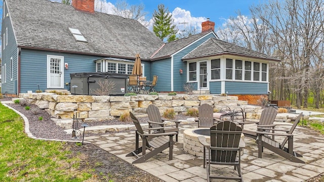 2066 County Road 125 E, Mahomet, IL 61853 - back of property with a patio, a chimney, a fire pit, and a hot tub