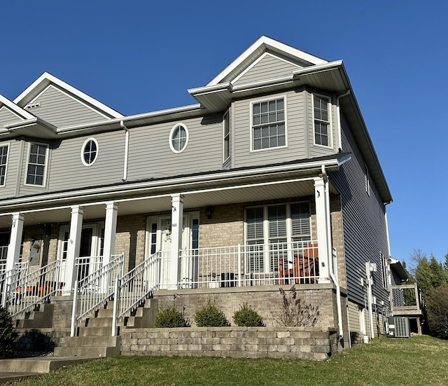 townhome / multi-family property with brick siding and a porch