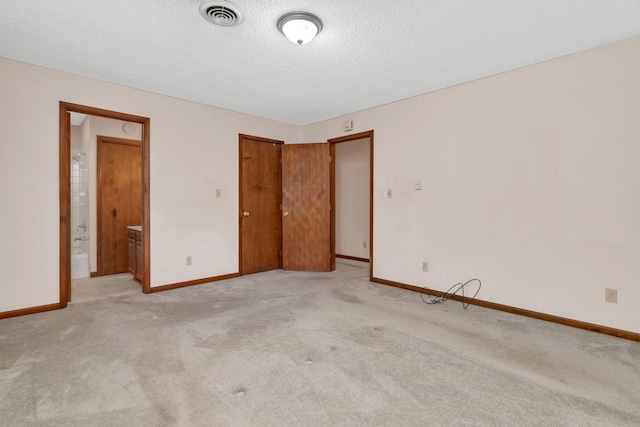 5815 E S Prairie Dr, Morris, IL 60450 - unfurnished bedroom with light carpet, baseboards, a textured ceiling, and connected bathroom