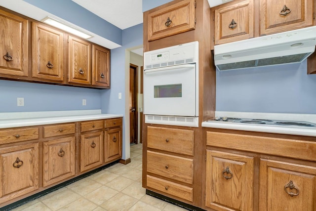 5815 E S Prairie Dr, Morris, IL 60450 - kitchen with white oven, under cabinet range hood, brown cabinets, and light countertops