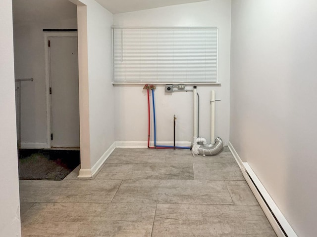 clothes washing area with a baseboard radiator, laundry area, and baseboards