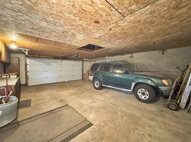 garage featuring a garage door opener and concrete block wall