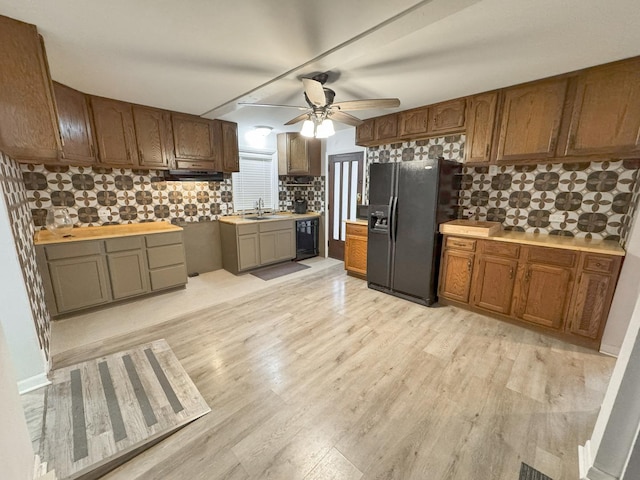 kitchen with light wood finished floors, a sink, black appliances, and ceiling fan