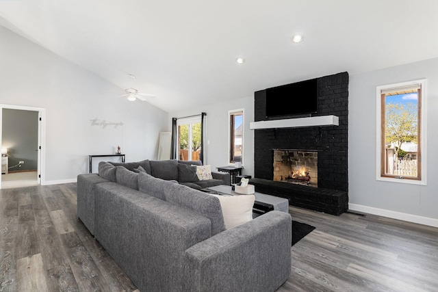 living room with ceiling fan, a fireplace, high vaulted ceiling, baseboards, and wood finished floors