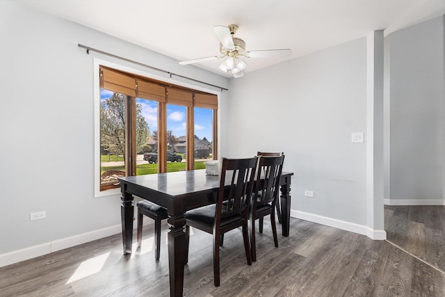 dining room with baseboards, a ceiling fan, and dark wood-style floors