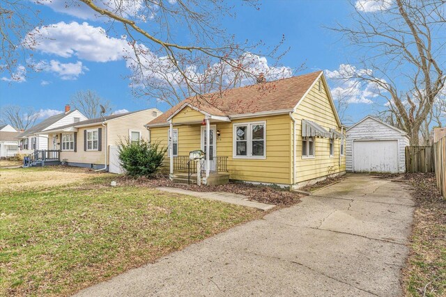 bungalow featuring fence, a garage, concrete driveway, a front yard, and an outdoor structure