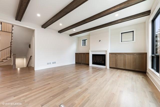260 E Grantley Ave, Elmhurst, IL 60126 - unfurnished living room featuring visible vents, beamed ceiling, a fireplace, and light wood-type flooring