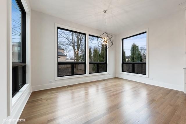 260 E Grantley Ave, Elmhurst, IL 60126 - unfurnished dining area with baseboards, wood finished floors, and an inviting chandelier