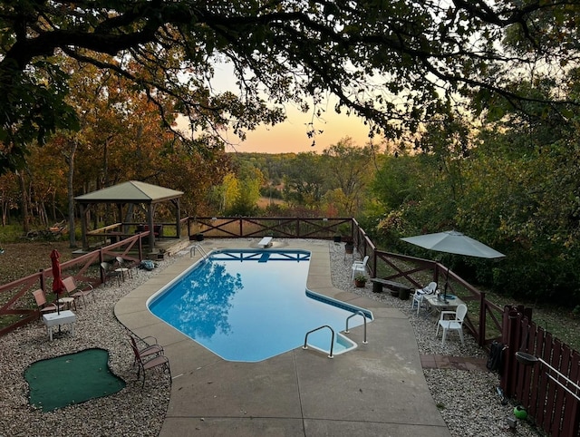 view of swimming pool featuring a fenced in pool, fence, a diving board, and a patio area