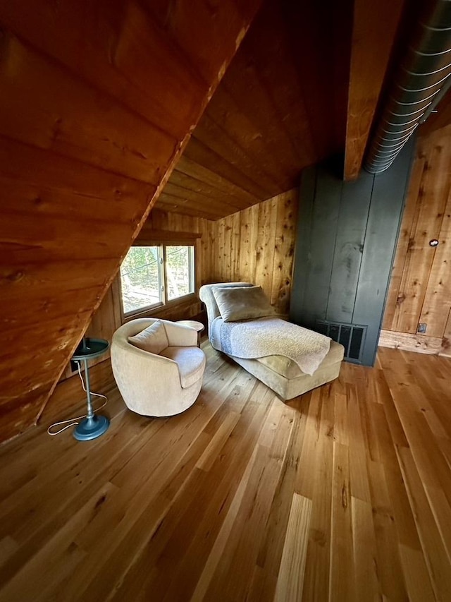unfurnished bedroom with wood ceiling, visible vents, wooden walls, and hardwood / wood-style flooring