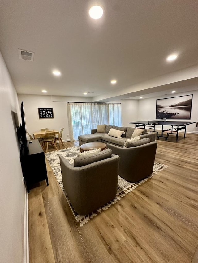 living room featuring visible vents, light wood-style flooring, and recessed lighting