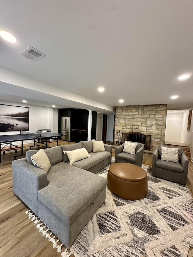 living room featuring visible vents, recessed lighting, light wood-type flooring, and a fireplace