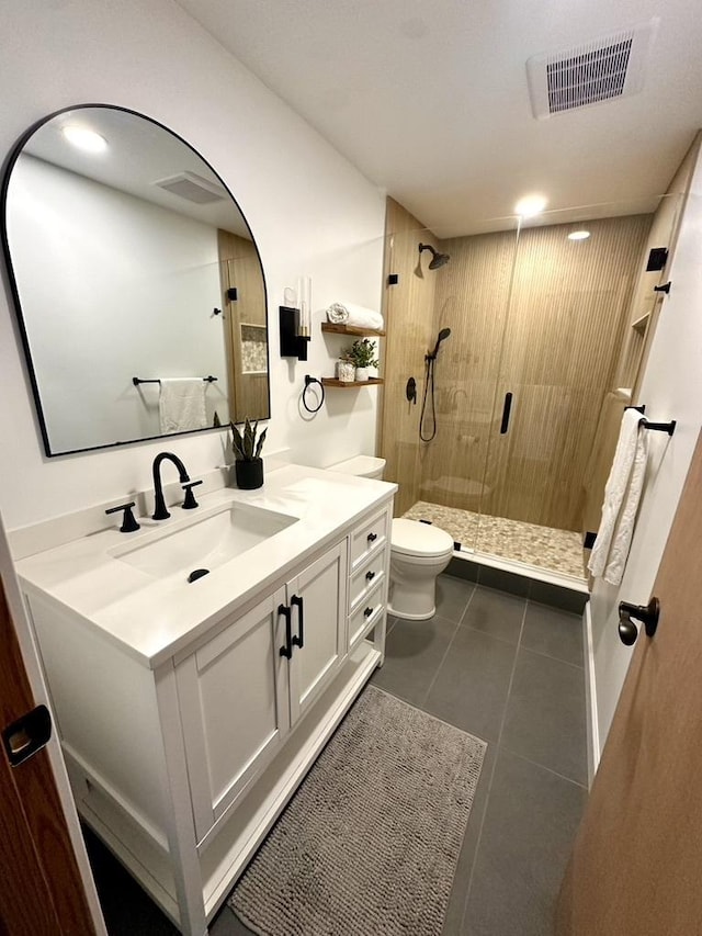 bathroom with a stall shower, tile patterned floors, toilet, vanity, and visible vents