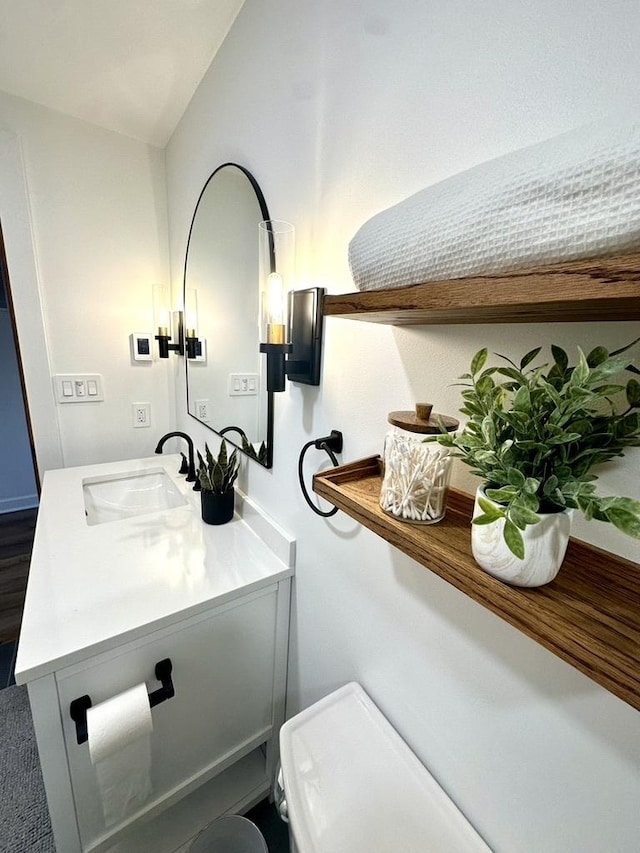 half bath featuring toilet, vanity, and lofted ceiling