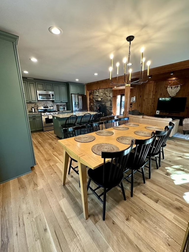 dining room featuring an inviting chandelier, light wood finished floors, and recessed lighting