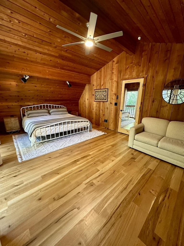 unfurnished bedroom featuring access to exterior, vaulted ceiling, wooden ceiling, wooden walls, and wood finished floors
