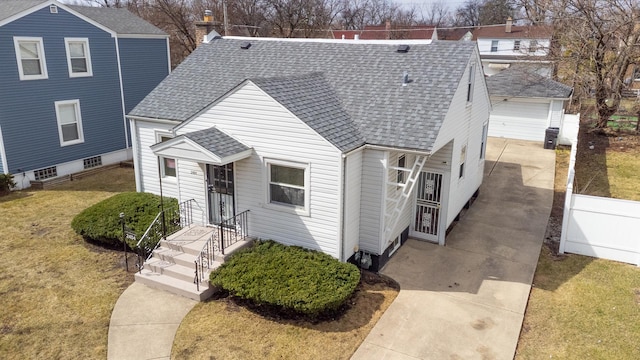 view of front of house with a garage, fence, a front yard, and roof with shingles