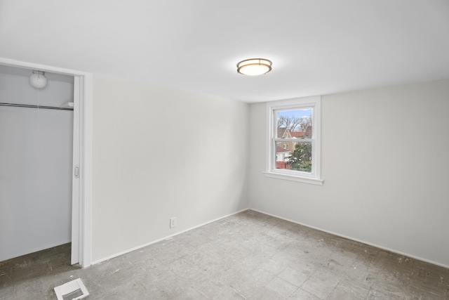 unfurnished bedroom featuring tile patterned floors, a closet, and visible vents