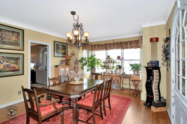 dining area with crown molding, wood finished floors, a chandelier, and baseboards