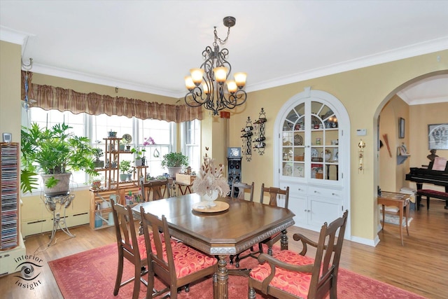 dining area with arched walkways, baseboard heating, ornamental molding, light wood finished floors, and a chandelier