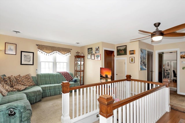 living room with a ceiling fan and light wood-style flooring
