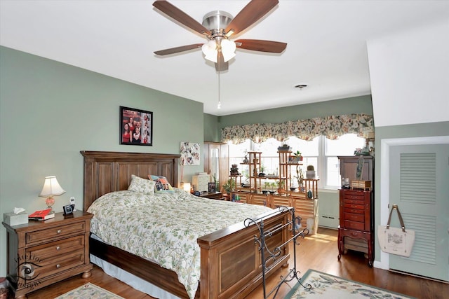 bedroom featuring a baseboard radiator and wood finished floors