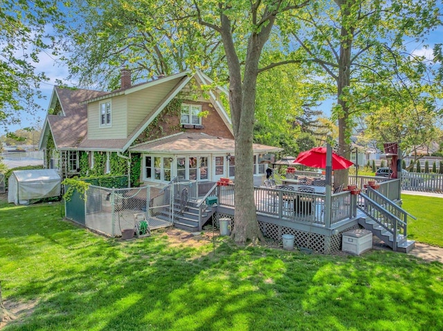 back of property with a chimney and a wooden deck