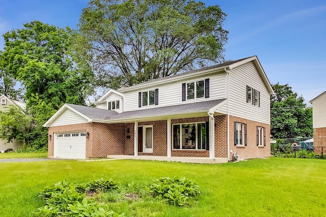 traditional-style house featuring roof with shingles, aphalt driveway, a front lawn, brick siding, and a garage
