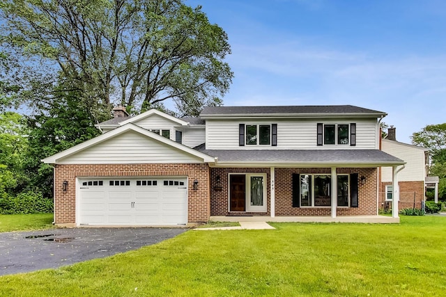 traditional-style house with aphalt driveway, an attached garage, a front yard, brick siding, and roof with shingles