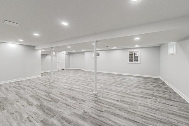 finished basement with baseboards, wood finished floors, and recessed lighting