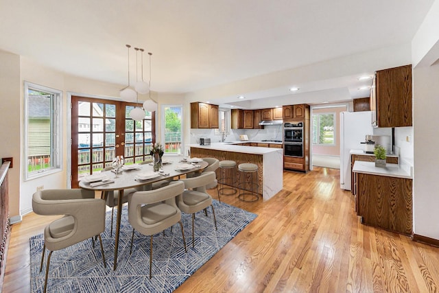 dining space with french doors, recessed lighting, baseboards, and light wood-type flooring